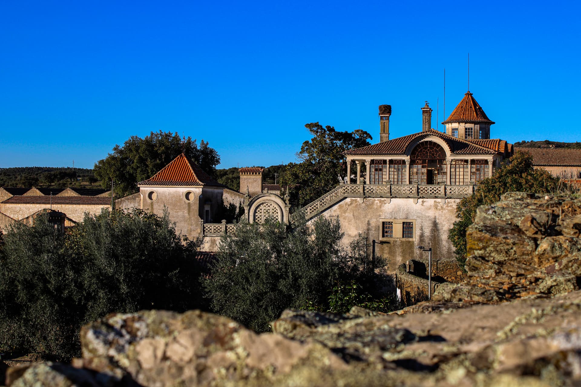 A historic manor house seen above the rooftops and ruins of Idanha-a-Velha